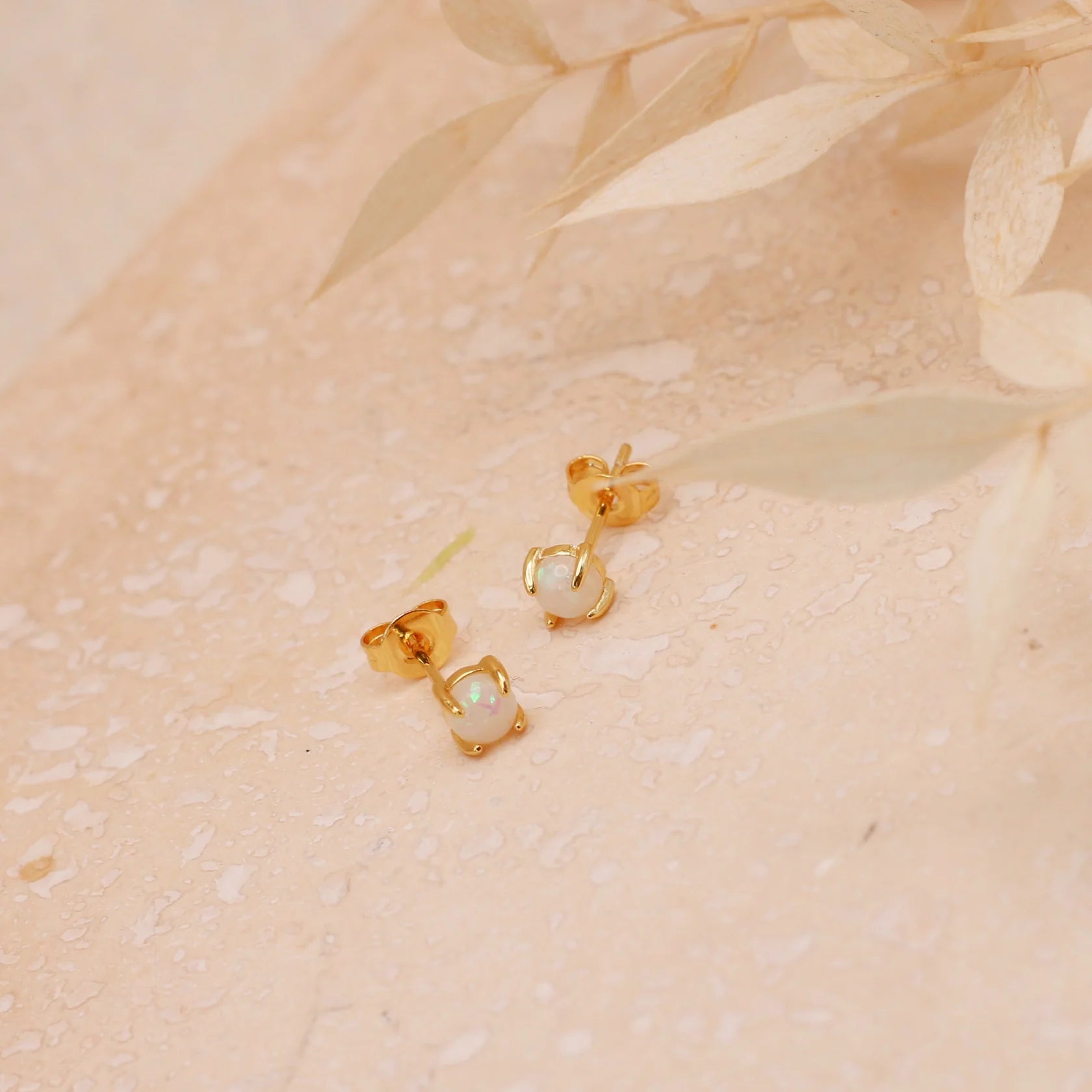 Two small gold stud earrings with Opal stones