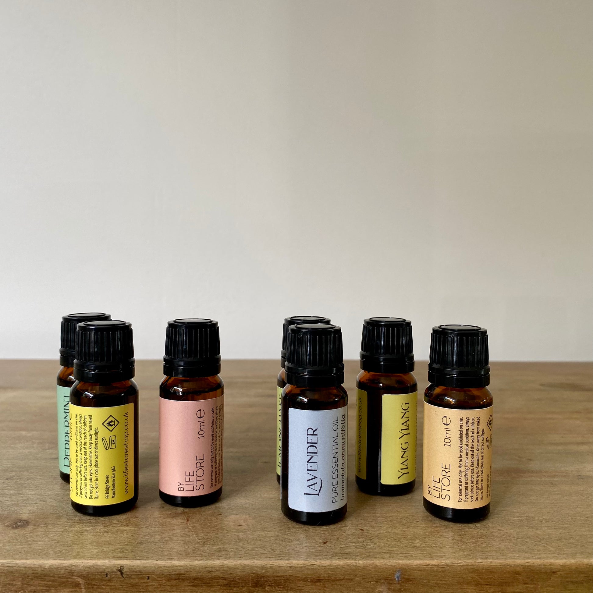 Selection of essential oils in small glass amber bottles with black lids and colourful labels
