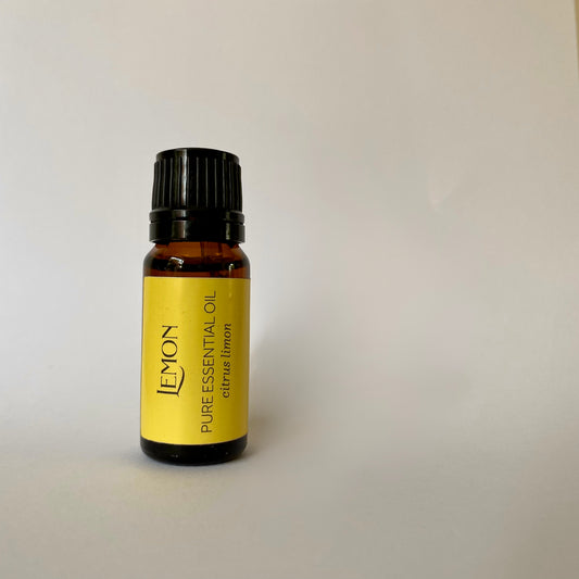 Small amber coloured glass bottle of essential oil with black lid and yellow label with lemon pure essential oil citrus limon printed in dark grey