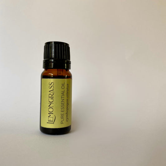 Small amber coloured glass bottle of essential oil with black lid and yellow label with lemon grass essential oil cymbopogon citratus printed in dark grey
