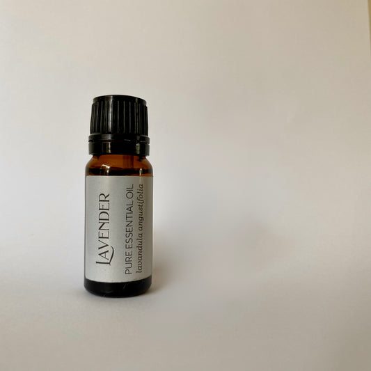 Small amber coloured glass bottle of essential oil with black lid and lilac label with  lavender pure essential oil lavandula angustifolia printed in dark grey