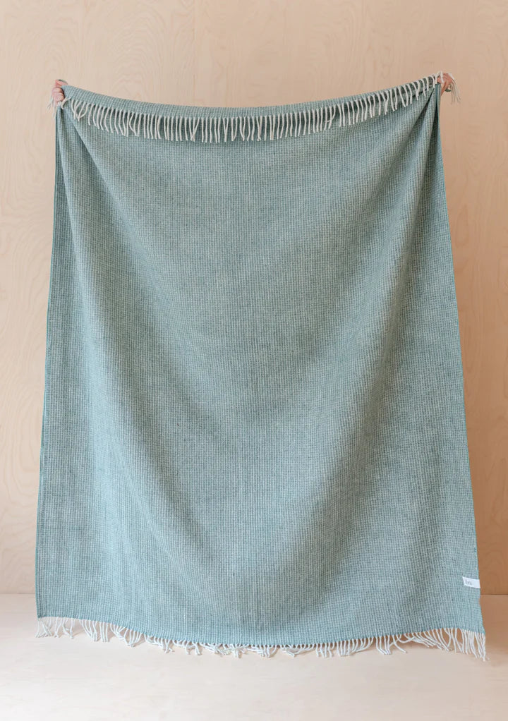 Large recycled wool sage green blue and cream waffle blanket with pale sage coloured tassels along the top and bottom edges